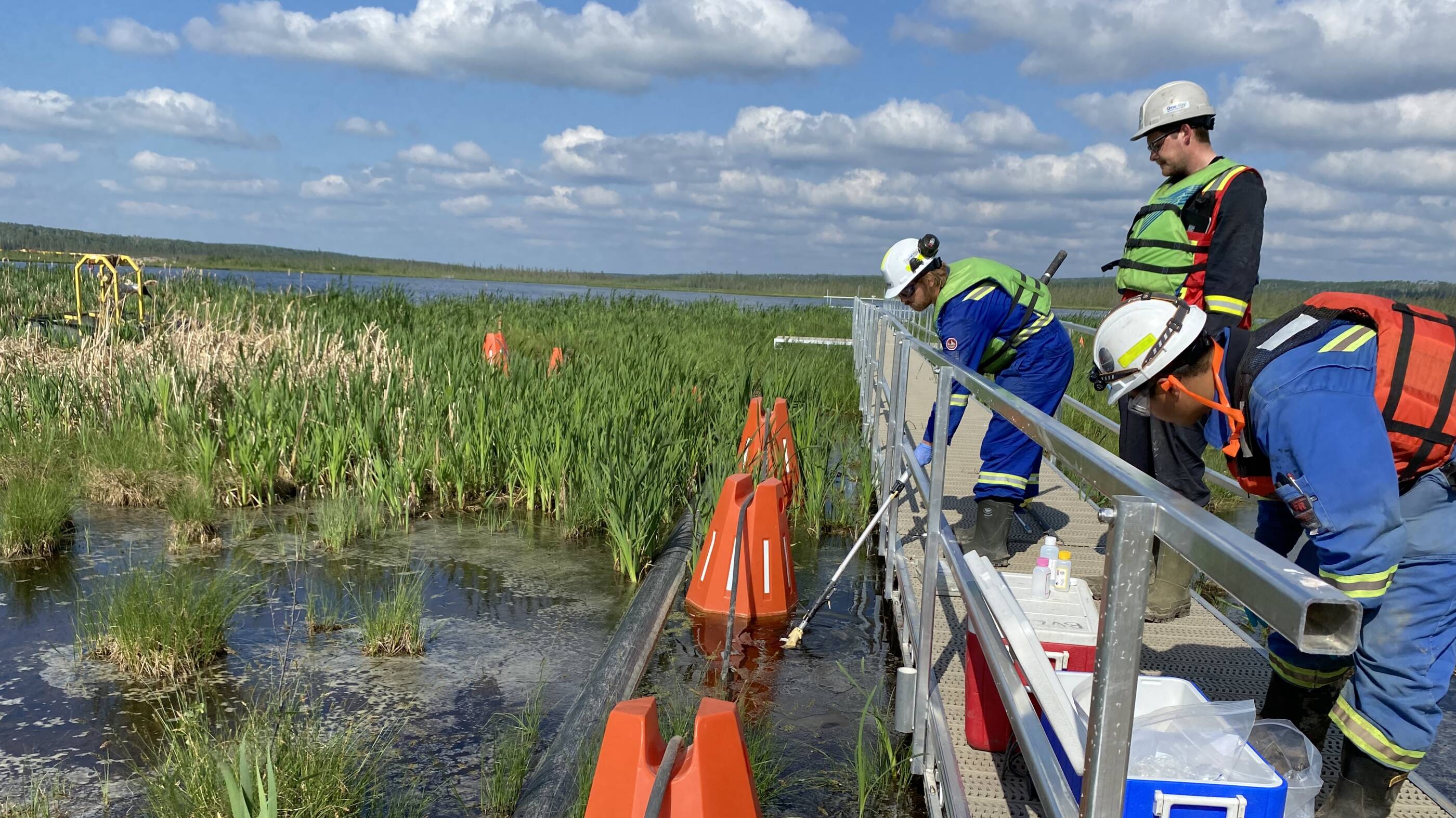 Kearl team members sampling water