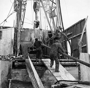 Image Drilling crew bringing up drill pipe on Bear Island adjacent to Norman Wells